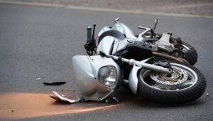 A damaged motorcycle lying on the road, leaving the injured rider to wonder about how to treat road rash from a motorcycle accident.
