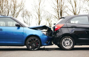 A side view of a black and a blue car in a rear-end collision.