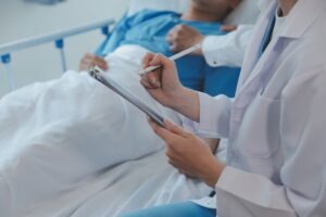 A doctor treating someone in a hospital bed. You can discuss your legal situation with an Estero catastrophic injury lawyer.