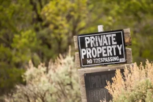 A no trespassing sign in some grass. A lawyer can explain what you should do immediately after an accident on someone else’s property.