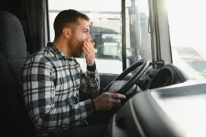 Tired truck driver yawning while driving. What impact does driver fatigue have on truck accident cases?