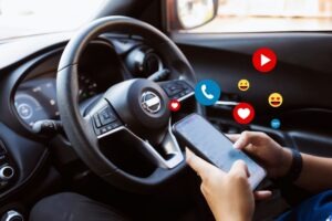 Person holding a smartphone while driving. How does distracted driving impact car accident claims?