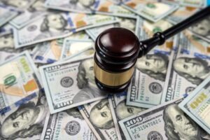 A gavel lying on a pile of cash. Learn about the average truck accident settlement amount.
