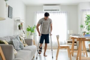 A man walking on crutches. A lawyer can explain what’s considered a catastrophic injury.