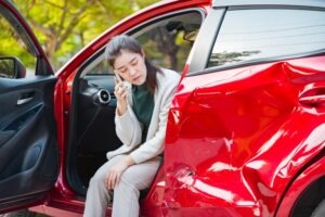 Lady on the phone after a car crash. Learn about the average car accident settlement in Florida.