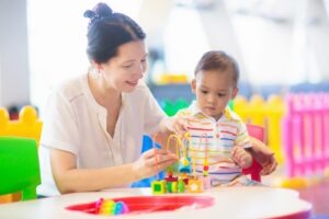 A little boy and an adult stand in front of a table, and the boy is playing with colorful toys. What is considered a daycare injury?