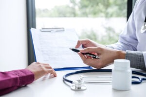 A doctor showing a patient their medical records and explaining how to prove black mold caused their health problems.
