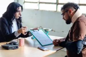 An injured man talks to his lawyer. A lawyer can tell you what happens if you were injured in a rideshare accident involving multiple vehicles.